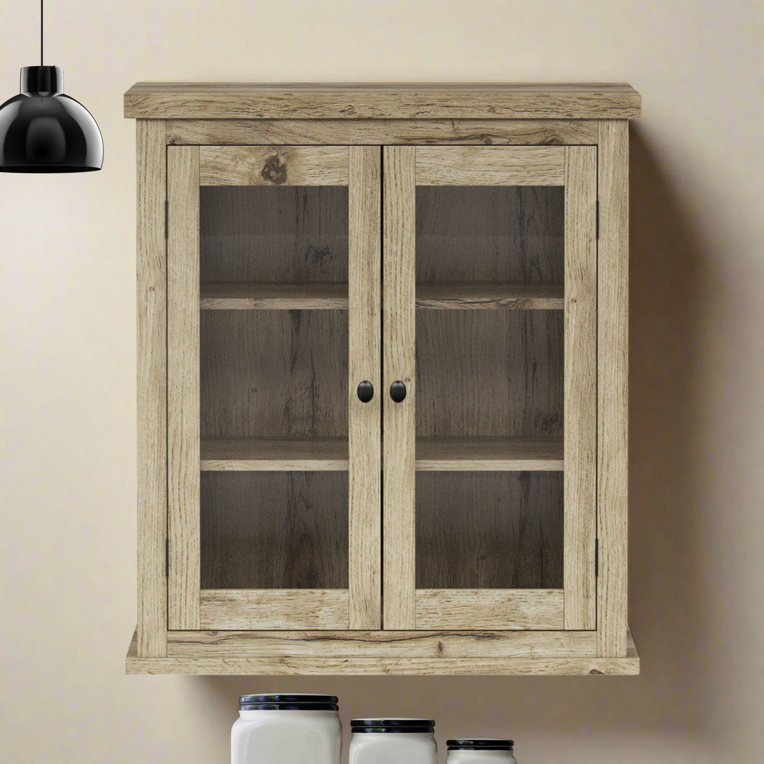 Light oak finished wall cabinet on a tan wall next to a black pendant light.