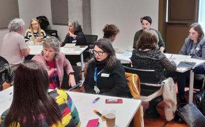 Photos of people sitting around small tables at the TU Dublin Engaged Research Network meeting 2023, involved in active discussion