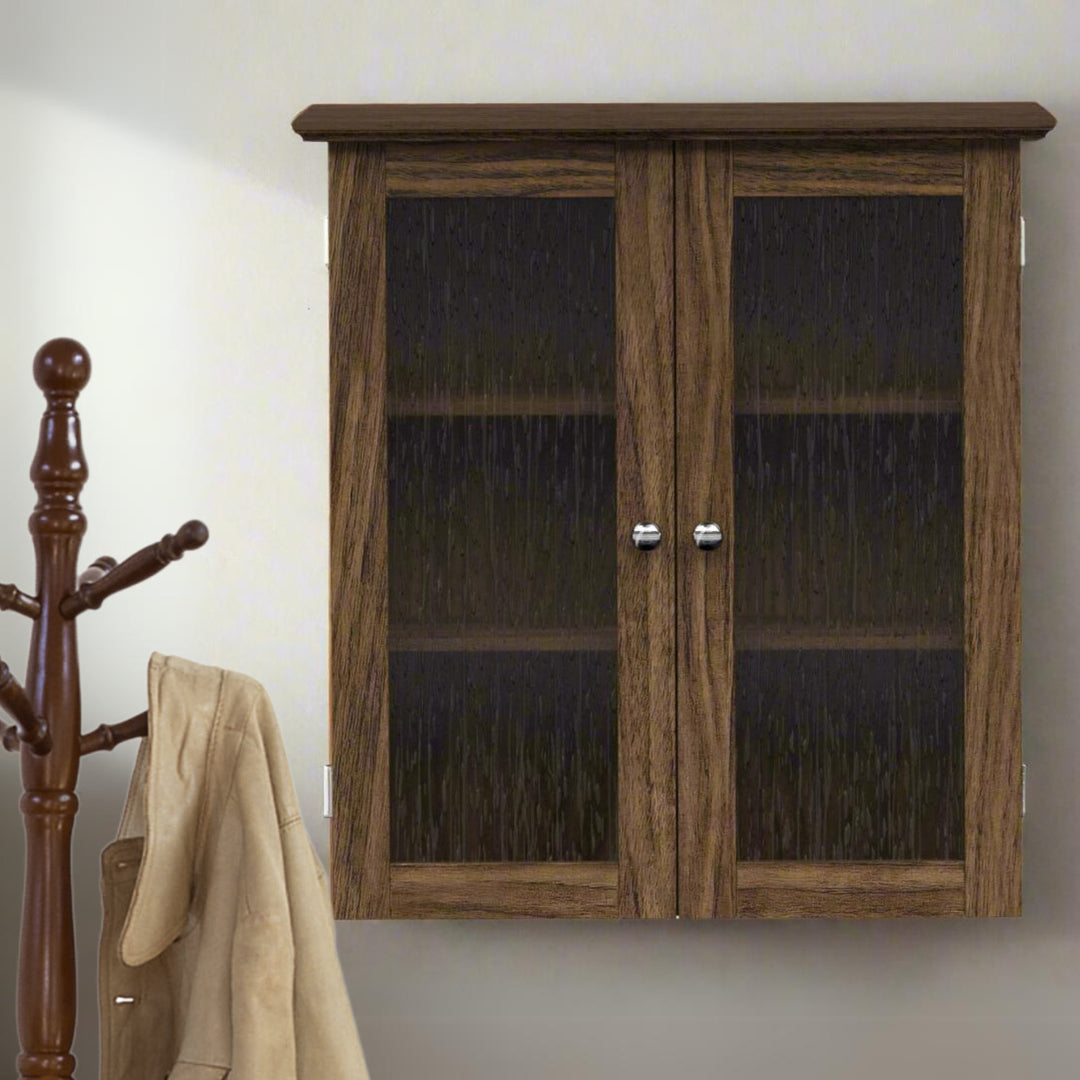 Walnut finished wall cabinet with two glass paneled doors on a white wall next to a coat tree.