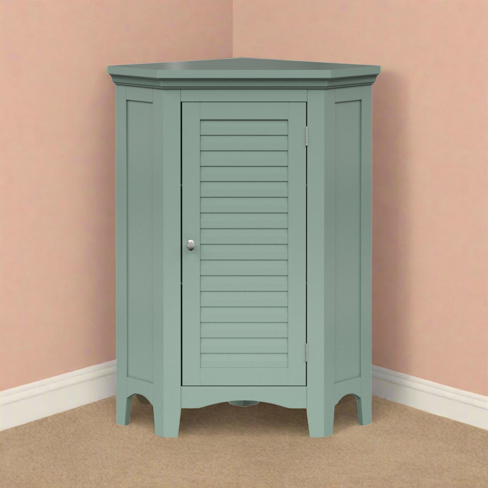 A sage green corner floor cabinet in a peach room on tan carpet.