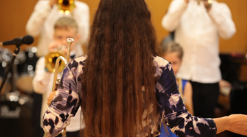 Image for Music conductor of a children's orchestra in a classroom