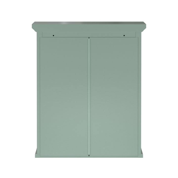 Back view of a sage green wall cabinet with chrome knobs and two faux louvered doors.