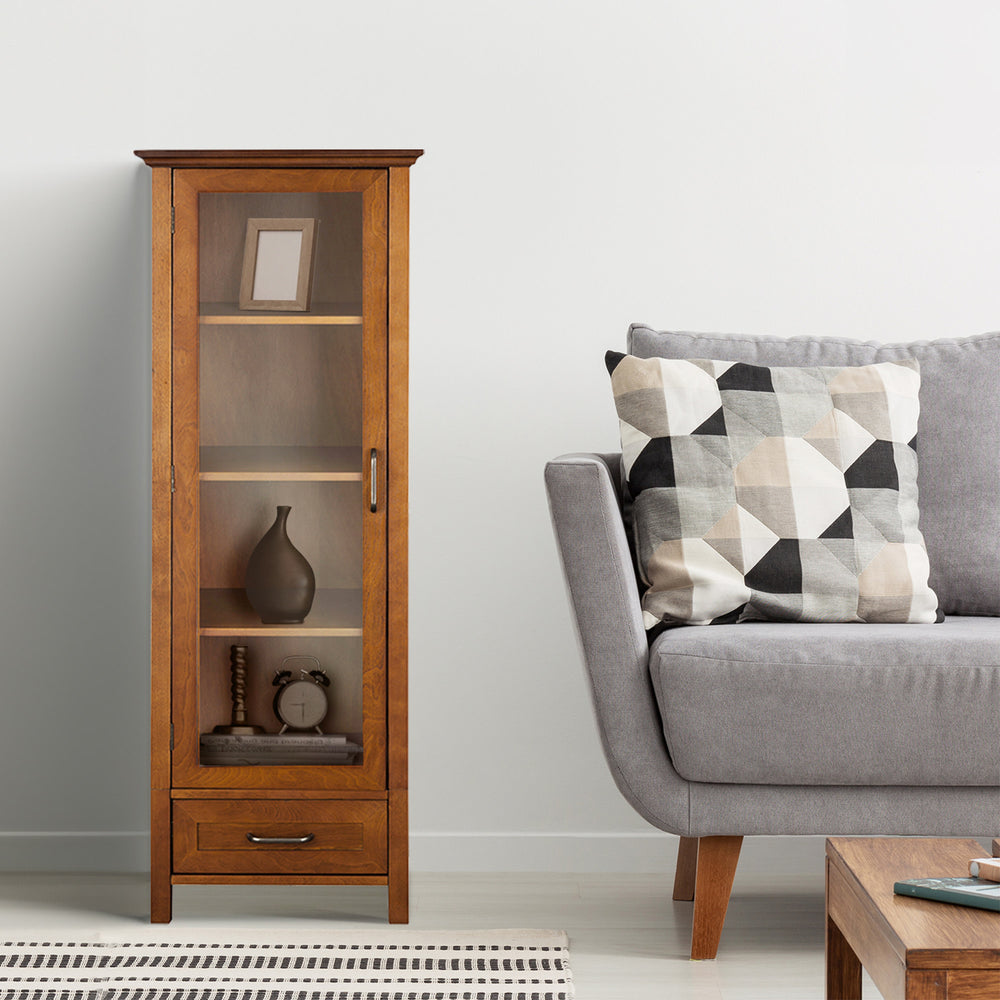 Tall cabinet with a glass door, four shelves and a bottom storage drawer with decor inside