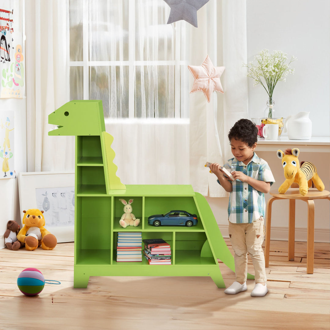 A boy reading a book next to a green dinosaur bookcase and toy organizer