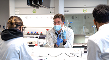 Image for A lecturer working with 2 students in a lab