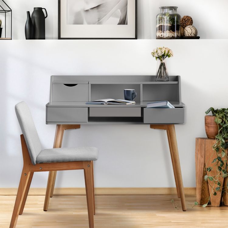 A gray office desk sits against a white wall in an office with a matching gray Teamson chair.