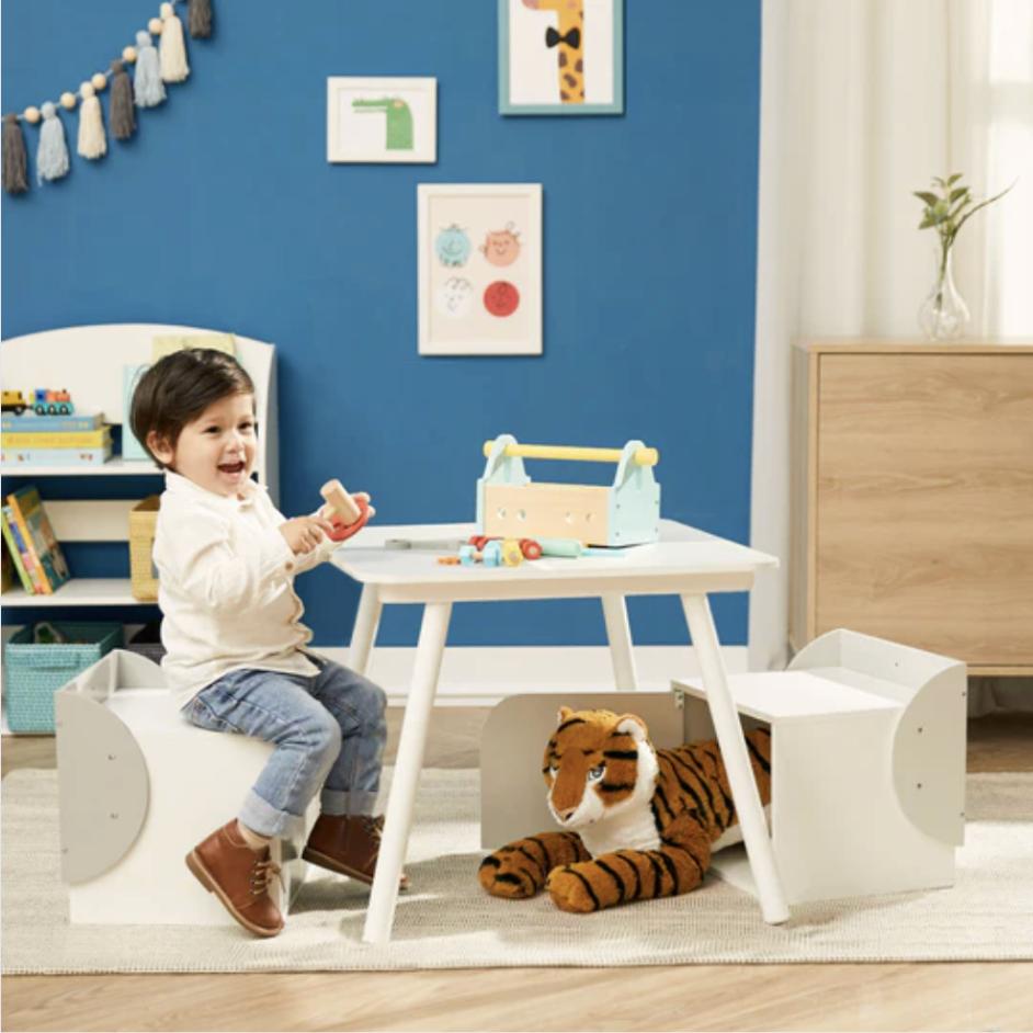 A young boy sits at a table sized just for him