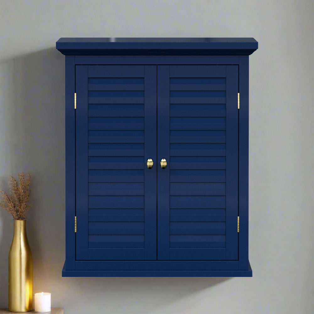 Navy blue wall cabinet with two faux louvered doors and gold hardware on a gray wall.