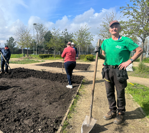 Image for Grangegorman Community Garden man standing at garden holding spade